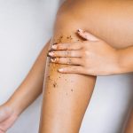 A Hand Applying Scrub on Her Leg