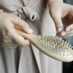 A Woman Removing Hair from a Hair Brush